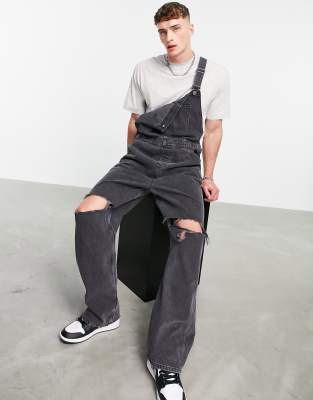 ASOS DESIGN - Salopette en jean baggy avec déchirures aux genoux - Noir délavé