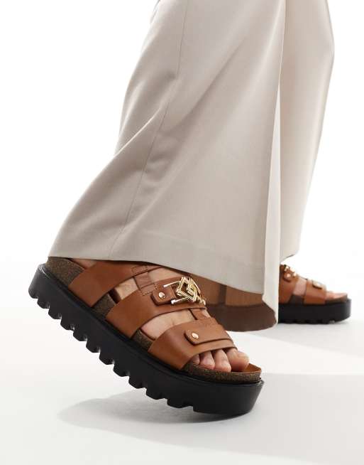 ASOS DESIGN Sandalen aus PU in Hellbraun mit dicker Sohle und goldfarbenen Monogramm Details ASOS