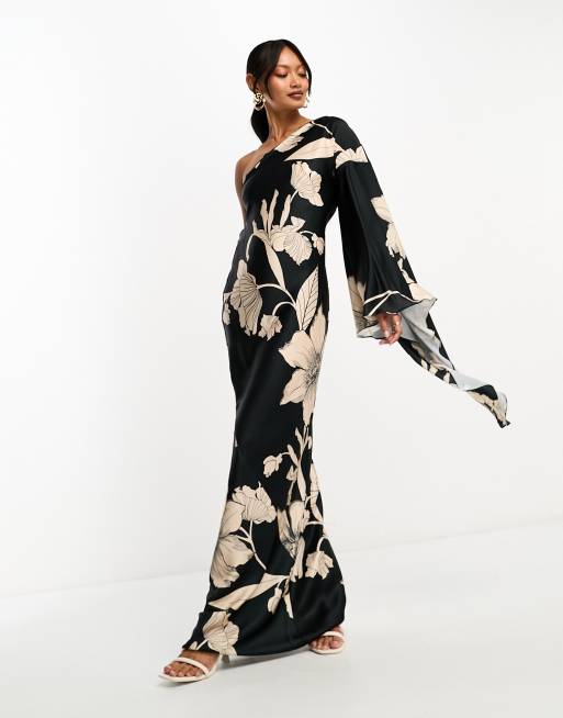 ASOS DESIGN - Satijnen maxi jurk met blote schouder en uitlopende mouw en bandjes aan de achterkant in zwart met bloemenprint