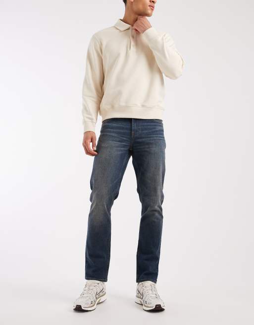 ASOS DESIGN – Schmal geschnittene Stretch-Jeans in verwaschenem Mittelblau mit Vintage-Waschung