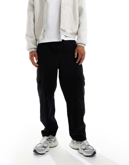 ASOS DESIGN – Schmal zu laufende Relaxed Fit Cargohose in Schwarz mit Bundfalten und elastischem Bund, 2 von 5
