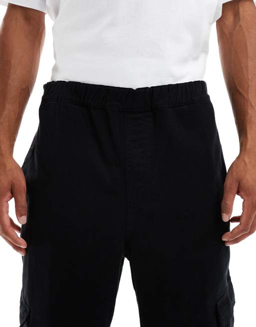 ASOS DESIGN – Schmal zu laufende Relaxed Fit Cargohose in Schwarz mit Bundfalten und elastischem Bund, 5 von 5