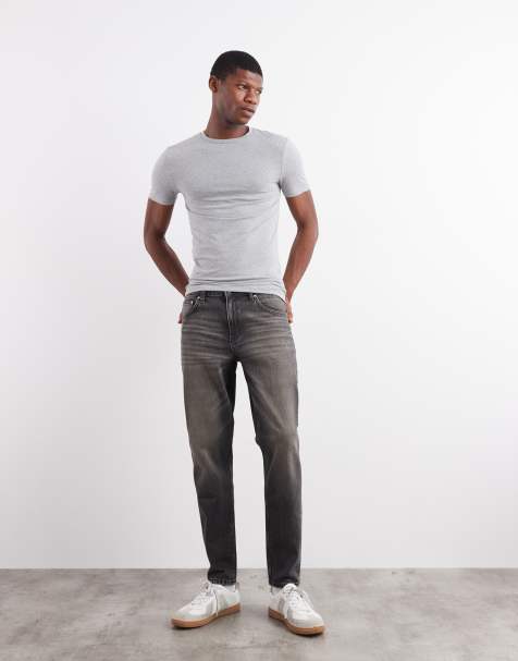 ASOS DESIGN – Schmal zulaufende Jeans in verwaschenem Schwarz mit Gelbstich - view 1