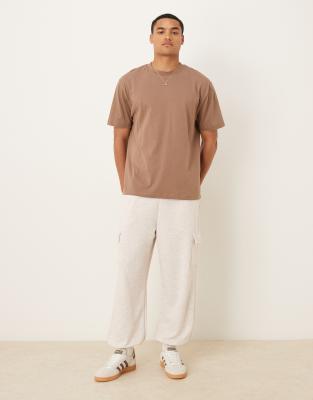 ASOS DESIGN – Schmal zulaufende Jogginghose aus Loopback in Steinbeige mit Cargo-Taschen - view 1