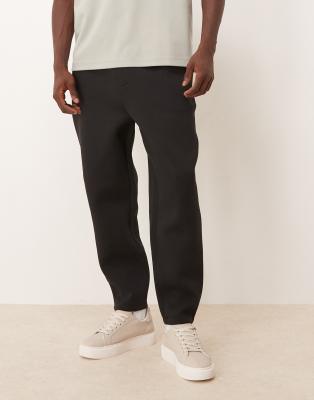Schmal zulaufende Jogginghose aus schwerem, neoprenartigem Material in Schwarz Schwarz L