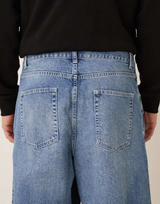 ASOS DESIGN – Schmal zulaufende Oversize-Jeans in verwaschenem Blau mit Falten, 5 von 5