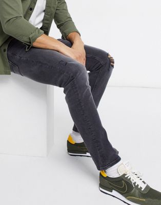ASOS DESIGN – Schmale Stretch-Jeans in verwaschenem Schwarz mit Riss am Knie und Abnutzungen