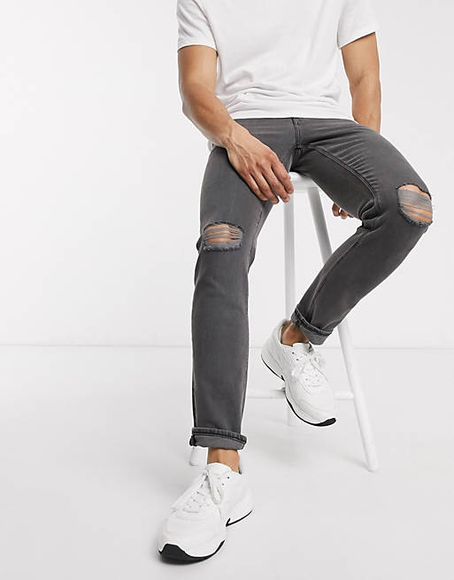 ASOS DESIGN – Schmale Stretch-Jeans in verwaschenem Schwarz mit Rissen am Knie