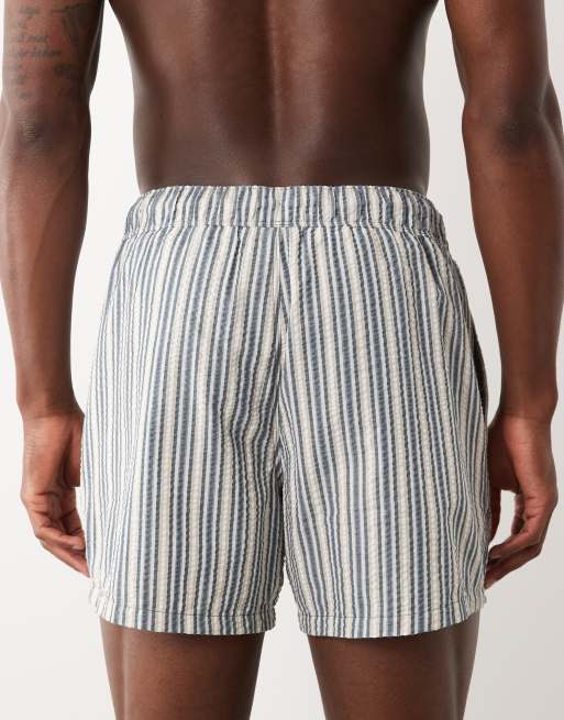 ASOS DESIGN seersucker stripe swim shorts in short length with badge in navy, 5 of 5