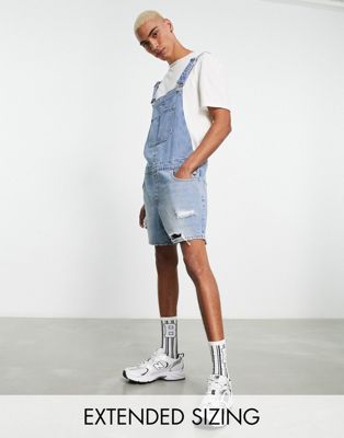 ASOS DESIGN short denim dungaree with shorter length in mid wash blue with rips