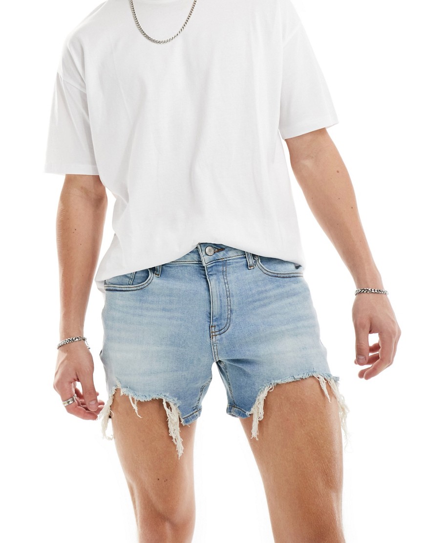 short length skinny denim shorts with heavy ripped hem in light wash blue