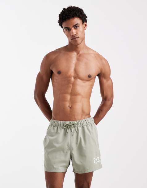 ASOS DESIGN short length swim shorts with placement print in sage green - view 1