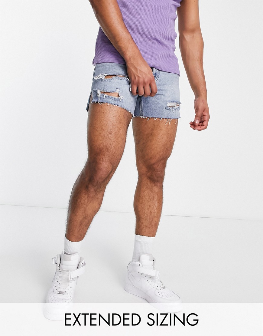 ASOS DESIGN shorter length denim shorts in mid wash with heavy rips-Blue