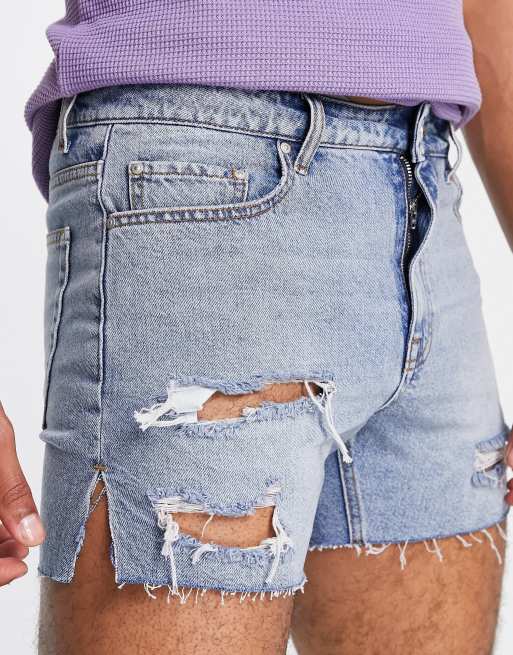 ASOS DESIGN shorter length denim shorts in mid wash with heavy rips