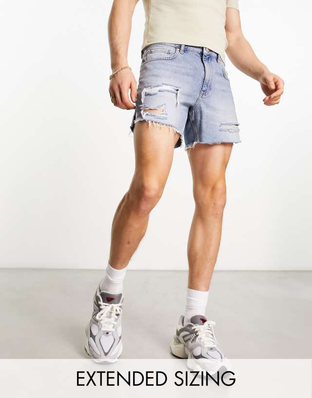 ASOS DESIGN shorter length denim shorts with rips in light wash blue