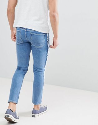 ASOS DESIGN skinny jeans in mid wash blue with frayed side stripe