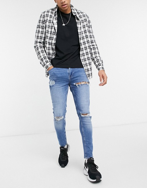 ASOS DESIGN skinny jeans in mid wash blue with heavy rips
