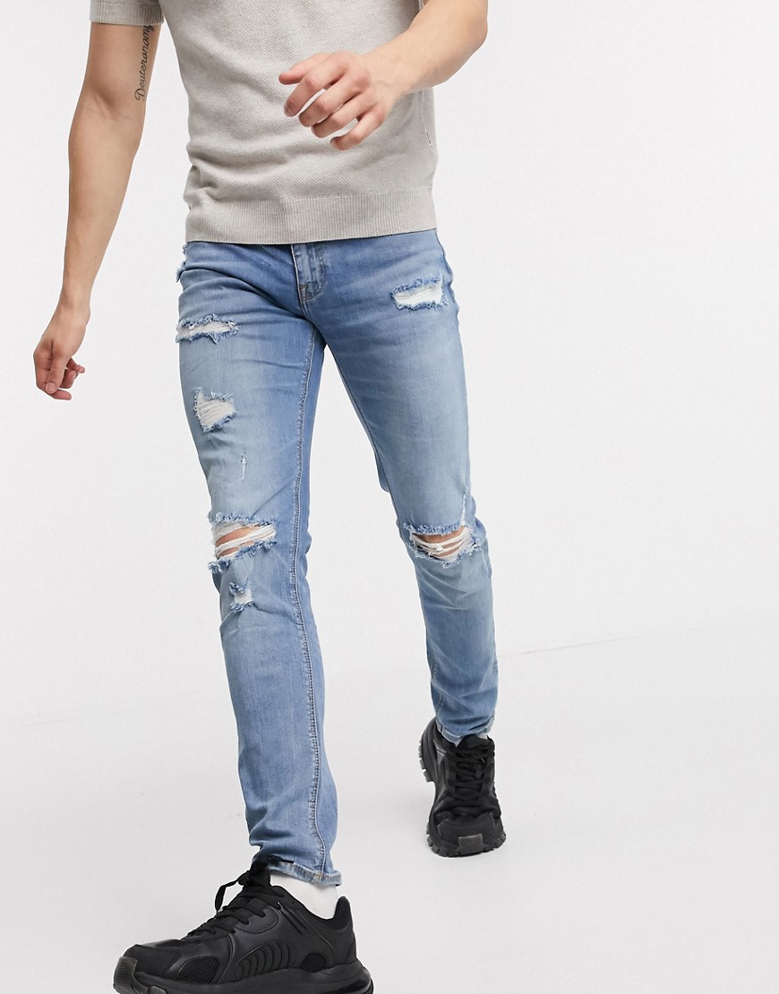 ASOS DESIGN skinny jeans in mid wash with heavy rips-Blue
