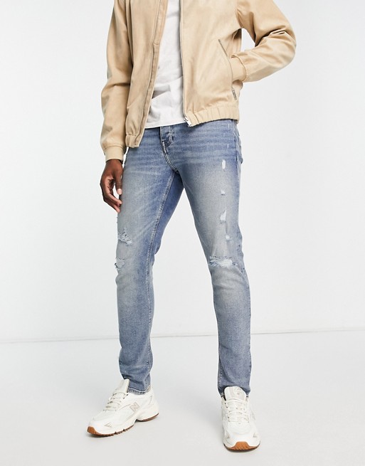 ASOS DESIGN skinny jeans in tinted light wash blue with rips