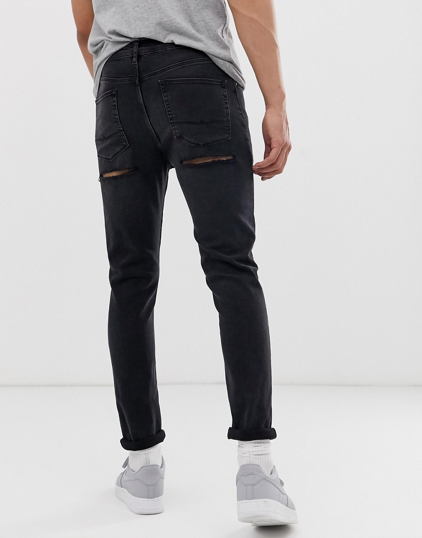 ASOS DESIGN skinny jeans in washed black with bum rips