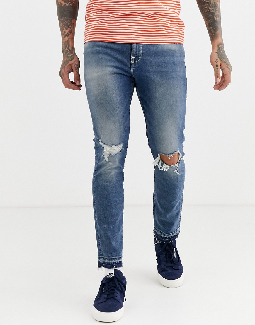 ASOS DESIGN - Skinny jeans met scheuren in midblauwe wassing