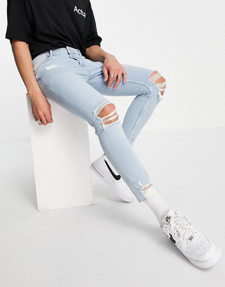 ASOS DESIGN skinny jeans with knee rips and destroyed hem in light wash blue-Blues