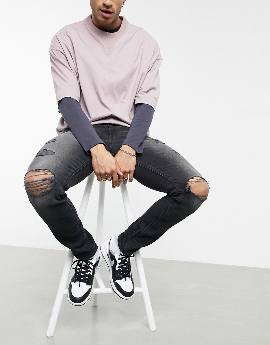 ASOS DESIGN skinny jeans with sustainable 'less thirsty' wash in black with heavy rips
