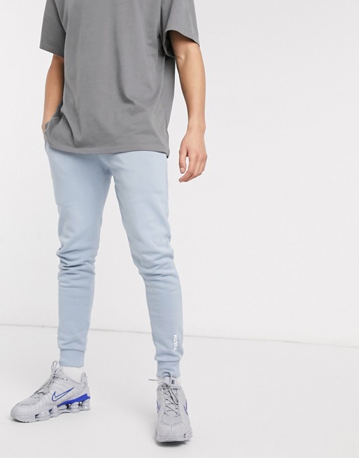 ASOS DESIGN skinny joggers in blue with youth print