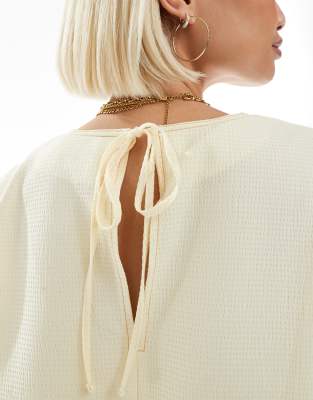 ASOS DESIGN sleeveless peplum top with tie back in yellow