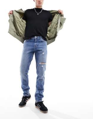 slim jeans with rips in mid wash blue