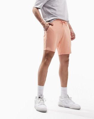 ASOS DESIGN slim jersey mid length shorts in pastel orange
