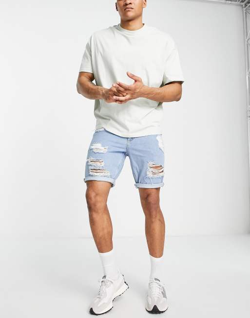 ASOS DESIGN slim mid length denim shorts with heavy rips in light wash