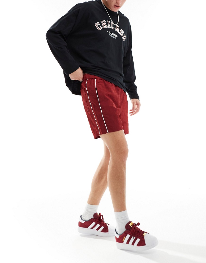 ASOS DESIGN slim nylon shorts with piping detail in burgundy-Red