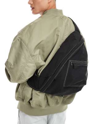 sling backpack in black with contrast stitch