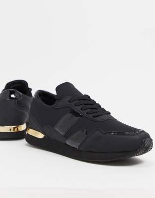 ASOS DESIGN sneakers in black with gold detail