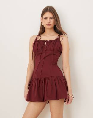 ASOS DESIGN - Sommerkleid in Minilänge aus Baumwoll-Satin in kräftigem Burgunderrot mit tiefer Taille und Bindedetail am...