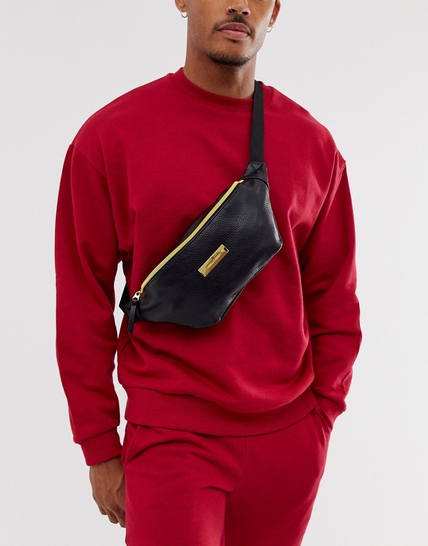 ASOS DESIGN — Sort bæltetaske med skulderstrop i imiteret læder og gylden lynlås og metallogo
