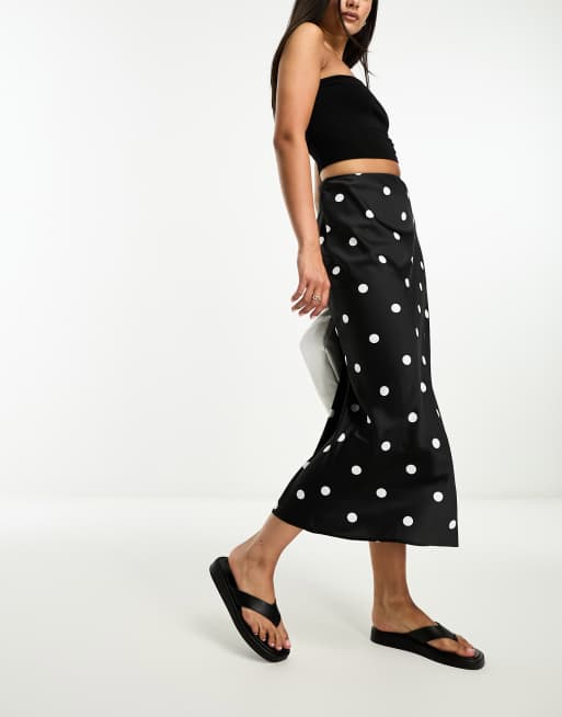 ASOS DESIGN - Sort midinederdel med skråsnit og hvide polkaprikker i satin 
