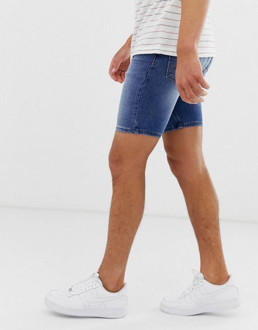 ASOS DESIGN stretch mid length denim shorts in flat mid wash blue
