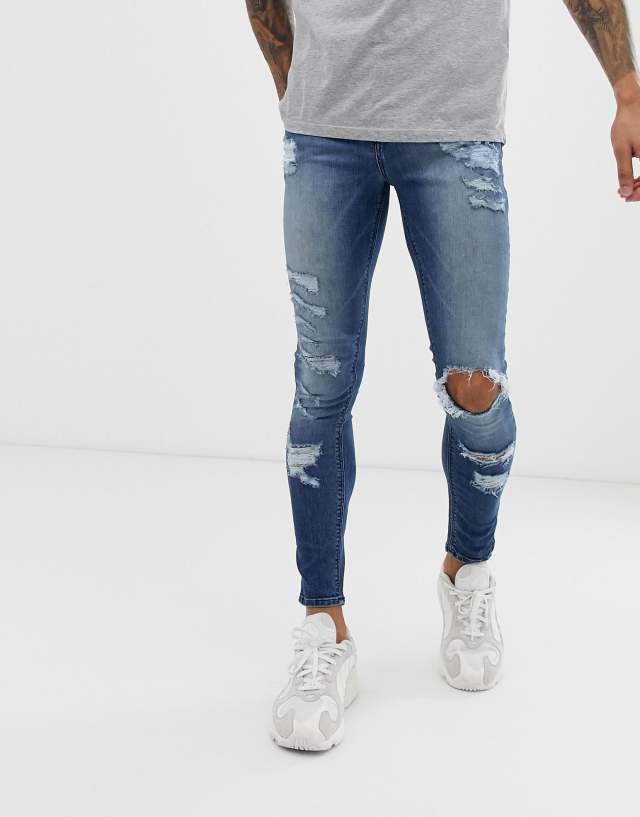 ASOS DESIGN spray on jeans in power stretch with heavy rips in mid wash blue