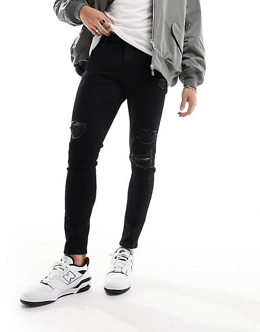 ASOS DESIGN spray on jeans with power stretch and heavy rips in black ...