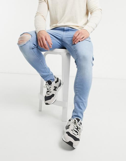 ASOS DESIGN spray on jeans with power stretch denim in light wash blue with abrasions