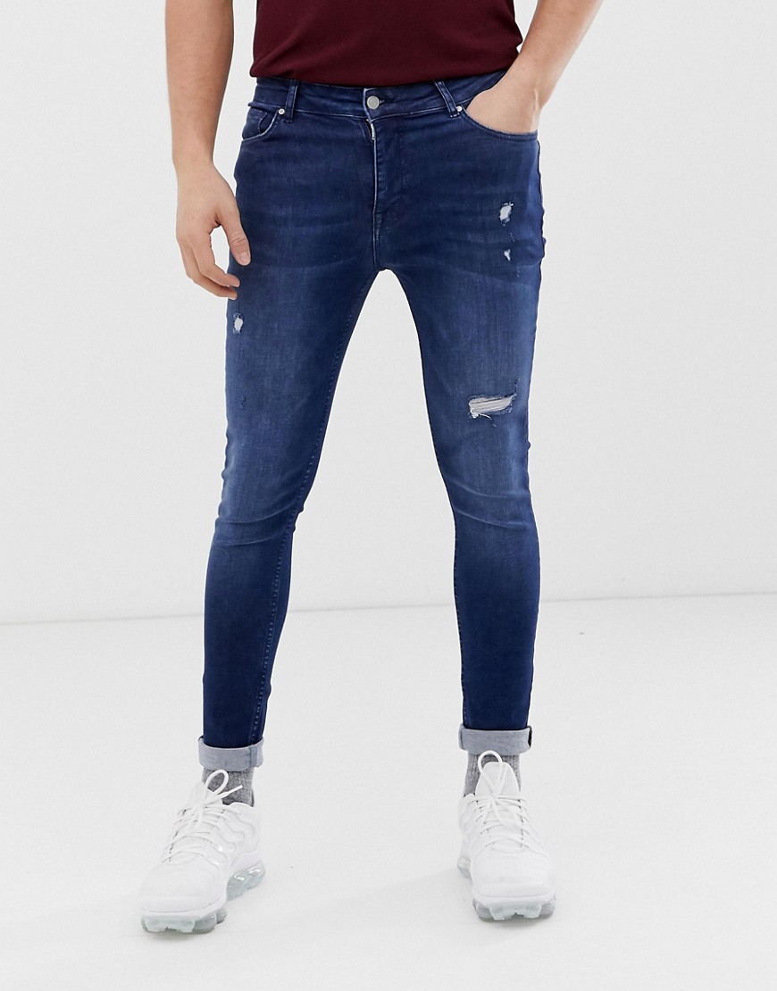 ASOS DESIGN spray on jeans with power stretch in blue with abrasions
