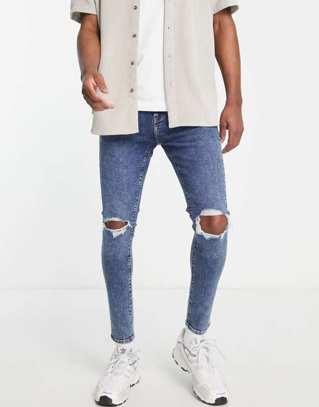 ASOS DESIGN spray on jeans with power stretch in dark wash blue with knee rips