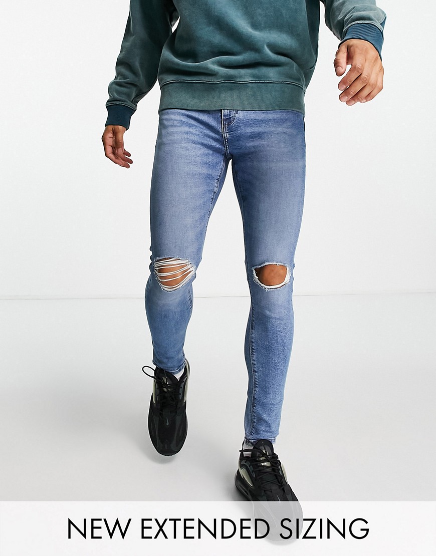 ASOS DESIGN spray on jeans with power stretch in mid wash blue with knee rips