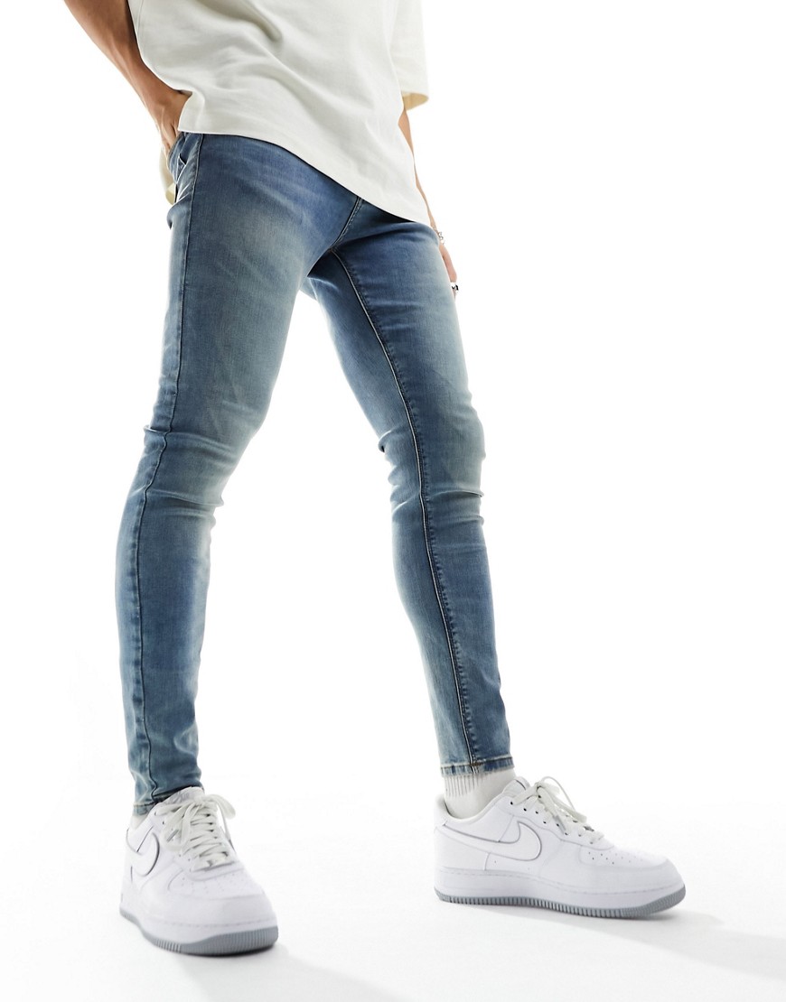 ASOS DESIGN spray on jeans with power stretch in tinted mid wash blue