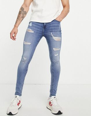 ASOS DESIGN spray on jeans with powerstretch in mid wash blue with heavy rips