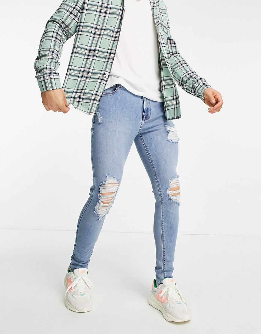 ASOS DESIGN spray on 'vintage look' jeans with powerstretch in mid wash with heavy rips-Blue