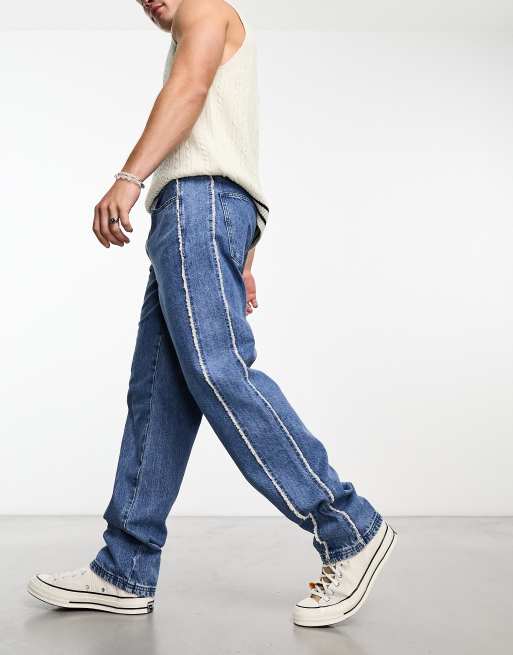 ASOS DESIGN straight leg jeans with fraying side seams in mid wash blue