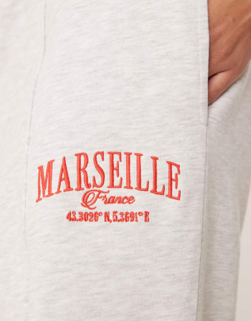 ASOS DESIGN straight leg sweatpants with Marseille embroidered graphic in ice heather, 3 of 5